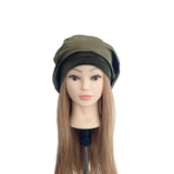 Mannequin head with long hair wearing a green beret on a white background