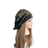 Mannequin head with olive green headscarf on a white background