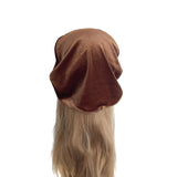 Brown beret on a mannequin head with blonde hair against a white background