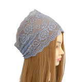 Lace headscarf on a mannequin head with long brown hair against a white background