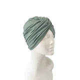 Green headscarf on a mannequin head against a white background