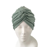 Green headscarf on a mannequin head against a white background