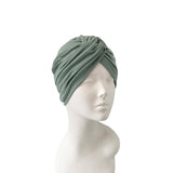 Green headscarf on a mannequin head against a white background