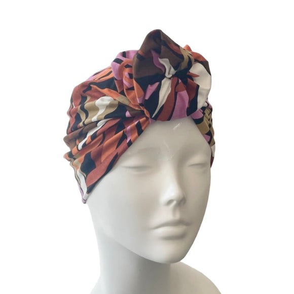 Colorful patterned headscarf on a mannequin head against a white background