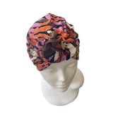 Colorful patterned headscarf on a mannequin head against a white background