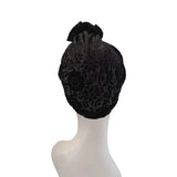 Black patterned headscarf on a mannequin head against a white background