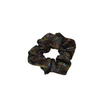 Black scrunchie with peacock feather pattern on a white background