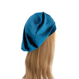 Blue beret on a mannequin head with blonde hair against a white background