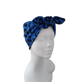 A blue and black leopard print knotted headwrap displayed on a white mannequin head against a plain white background.