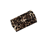 A leopard print headband with a twisted knot detail, shown on a plain white background.