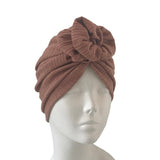 Brown turban on a mannequin head against a white background