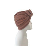Brown turban on a mannequin head against a white background