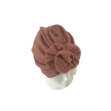 Brown textured headscarf on a mannequin head against a white background