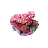 Stack of colorful baby clothes on a white background
