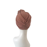 Brown turban on a mannequin head against a white background
