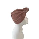 Brown turban on a mannequin head against a white background