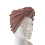 pink knotted headband on a mannequin head against a white background