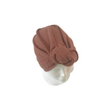 Brown knitted turban on a mannequin head against a white background