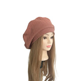 Mannequin head with long brown hair wearing a brown beanie on a white background