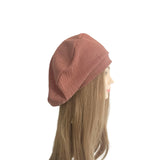 Mannequin head wearing a pink knit beanie on a white background