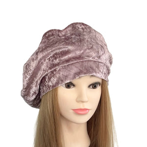 Mannequin head wearing a mauve velvet turban on a white background