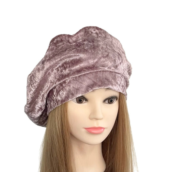 Mannequin head wearing a mauve velvet turban on a white background
