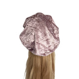 Metallic pink hair bonnet on a mannequin head with blonde hair against a white background
