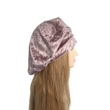 Mannequin head wearing a pink velvet headband on a white background