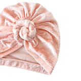 Pink velvet turban with a knot on a white background