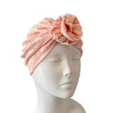 Pink towel turban on a mannequin head against a white background