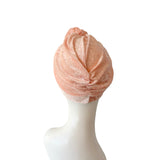 Pink turban on a mannequin head against a white background