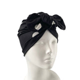 Black headscarf with knot on a mannequin head against a white background ireland