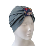 Gray headscarf with a floral pattern on a mannequin head against a white background