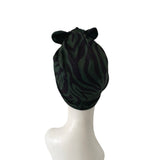 Black zebra-striped headscarf on a mannequin head against a white background