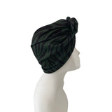 Black patterned headscarf on a mannequin head against a white background