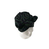 Black patterned headscarf on a mannequin head against a white background