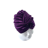 Purple turban on a mannequin head against a white background
