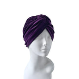 Purple turban on a mannequin head against a white background