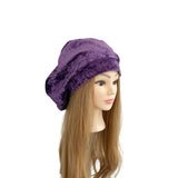 Purple velvet hat on a mannequin head with long brown hair against a white background