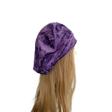 Purple velvet headscarf on a mannequin head with blonde hair against a white background