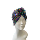 Colorful sequin turban on a mannequin head against a white background