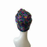 Multicolored sequin head wrap on a mannequin head against a white background