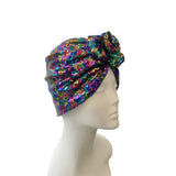 Multicolored sequin head wrap on a mannequin head against a white background