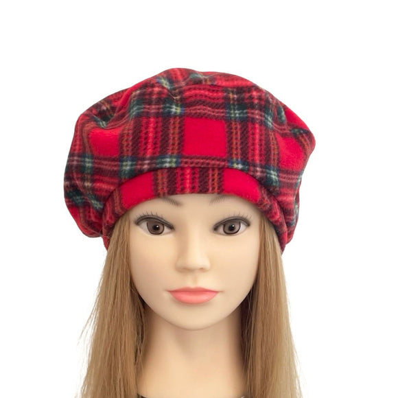 Mannequin head with long hair wearing a red plaid hat on a white background