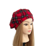 Red plaid hat on a mannequin head with long brown hair against a white background
