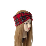 A red plaid headband with a twisted knot detail, displayed on a mannequin head with long light brown hair against a plain white background.