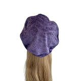 Purple satin hair bonnet on a mannequin head with blonde hair against a white background