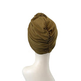 Brown turban on a mannequin head against a white background