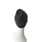 Black and gray patterned headscarf on a mannequin head against a white background