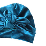 Blue velvet turban with a knot on a white background